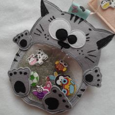 a close up of a cat shaped brooch on a white cloth material with other items in the background