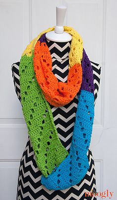 a multicolored crocheted scarf hanging on a mannequin