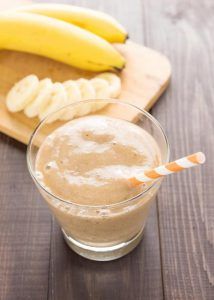 there is a smoothie and bananas on the table