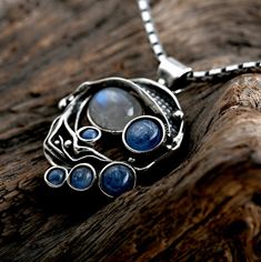 "From Porans collection ---->Unique sculpted silver vintage pendant with Moonstone oval (10/8)and 5 Kyanite stones. A beautiful pendant for holiday gift design by Amir poran. MATCHING RING: https://www.etsy.com/il-en/listing/128451738/handcrafted-sterling-silver-statement?ref=shop_home_active_1&pro=1&frs=1 Pendant Dimensions: Max height: 1.3 inches Max Width: 1 inches The length of the chain is usually 18\"- 22\", An amazing gift for yourself or loved ones! Comes in a beautiful jewelr Elegant Engraved Moonstone Jewelry, Vintage Silver Necklace With Stone Setting, Silver Fusion Moonstone Jewelry, Silver Moonstone Fusion Jewelry, Moonstone Pendant Amulet Jewelry, Moonstone Amulet Pendant Jewelry, Antique Silver Jewelry With Natural Stones, Vintage Jewelry Pendant With Stone Setting, Vintage Pendant Jewelry With Stone Setting