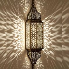 an intricately designed light fixture casts a shadow on the wall