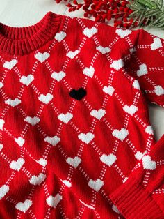 Hand-knitted red hand-knitted sweater with white hearts and one black heart on the chest. This sweater is hand knitted in soft merino wool or cotton. The model of the sweater is loose, with a lowered shoulder. You can order in any size or make changes to your order in the section - personalization. It is also possible to choose a different color for the base color of the sweater. Pictured is size S. Size Parameter: Size XS: length - 58 cm, width 46 cm Size S: length - 60 cm, width - 48 cm Size M Heart-shaped Knit Sweater For Winter, White Heart Sweater For Winter, White Heart Print Sweater For Winter, Winter Heart-shaped Sweater With Heart Print, Winter Knit Sweater With Heart Print, Winter Heart Print Sweater, Knit Sweater With Heart Print For Winter, Cozy Knit Sweater With Heart Design, Knit Crew Neck Sweater With Heart Print