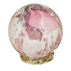 a pink and white marble ball sitting on top of a wooden stand with gold accents