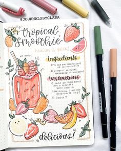 a notebook with some fruit on it next to markers, pens and pencils that read tropical smoothie