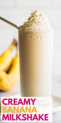 a banana milkshake with whipped cream on top and two bananas in the background