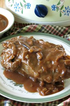 a white plate topped with meat covered in gravy