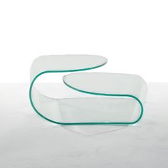 two glass tables sitting on top of a white floor next to each other, one with a curved edge