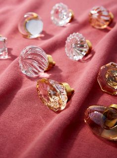 several glass knobs on a pink cloth