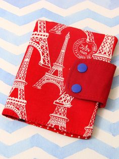 a red wallet with the eiffel tower on it and blue buttons in front