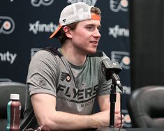 a man sitting in front of a microphone with an orange visor on his head