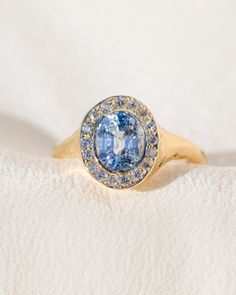 *One of a Kind* hand-carved 14k Yellow Gold ring, set with a stunning oval Sri Lankan Lavender Sapphire, surrounded by a halo of White Diamonds. Center Sapphire is approx. 7 x 6mm and 1.65 ct. 💌 Please write desired size (between 4-8) in *Notes* section at checkout. * Lavender Sapphire from Sri Lanka, is a stone of deep awakening, stimulating the rise of the kundalini transformation energy, while opening your connection with your spirituality. Opening the third eye and crown chakras, it imparts Oval Tanzanite Jewelry With Halo Design, Oval Tanzanite Halo Jewelry, Heirloom Sapphire Halo Ring With Halo Setting, Oval Sapphire Ring With Halo, Oval Sapphire Ring With Halo Setting In 14k Gold, Heirloom Oval Tanzanite Ring, Oval Cluster Ring With Bezel Setting In Fine Jewelry, Oval Cluster Ring With Bezel Setting, Oval Yellow Gold Sapphire Ring With Halo Design