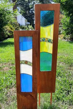 two stained glass panels sitting in the grass