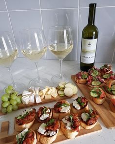 a table topped with lots of food and glasses of wine next to bottles of wine