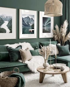 a living room with green walls and pictures on the wall above the couch, coffee table