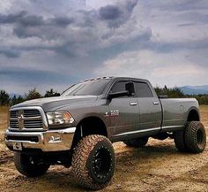 a large gray truck parked on top of a dirt field