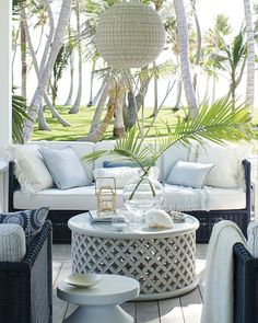 an outdoor living area with wicker furniture and palm trees