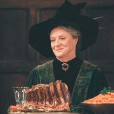 an older woman wearing a witches hat and holding a platter with meat on it