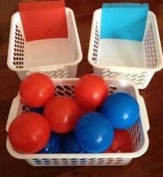 two plastic baskets filled with balloons on top of a wooden floor next to a sign that says toddler's first color sort