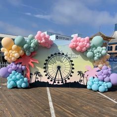 balloons are floating in the air near a ferris wheel