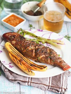 there is a fish and asparagus on the plate with sauces next to it