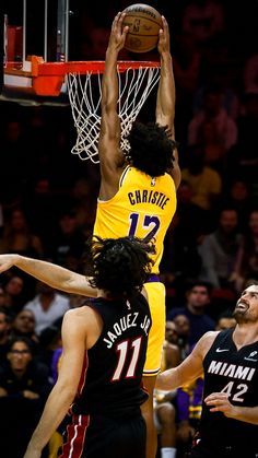 the basketball players are trying to block the ball from going into the basket in front of them