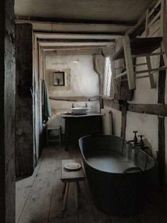 an old fashioned bathtub and sink in a rustic bathroom