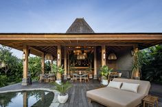 an outdoor living area with couches and tables next to a pool in the middle