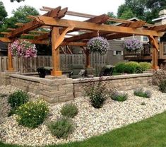 an outdoor patio with stone walls and wooden pergols on the side of it