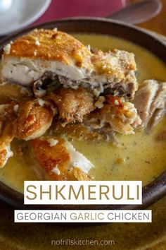 a bowl filled with chicken and gravy on top of a table