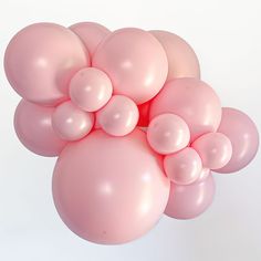 a bunch of pink balloons floating in the air