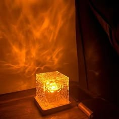 a lit candle sitting on top of a wooden table