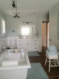 a bathroom with a tub, sink, and toilet in the middle of it's room