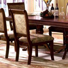 a dining room table with chairs and a wine bottle on top of the wooden table