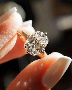 a close up of a person holding a ring with a diamond in it's middle