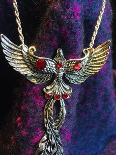 This is a stunning Phoenix necklace, with a stainless steel body and ruby-red rhinestones. The phoenix is a mythical animal which, according to legend, eternally rises from its own ashes. It is thus a symbol of life which never ends, eternity and resurrection. If you feel like you are ready for a new life, to rise from the ashes of your own existence, then wear this animal on your heart. It will protect you and remind you of your own inner strength! It is approx. 2.75 x 3.5 inch (7x9cm) and manu Symbol Of Life, Phoenix Necklace, Phoenix Pendant, Rise From The Ashes, Mythical Animal, Angel Necklace, Angel Pendant, Life Symbol, Red Rhinestone