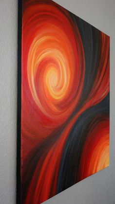 a painting hanging on the wall with an orange and black swirl painted on it's side