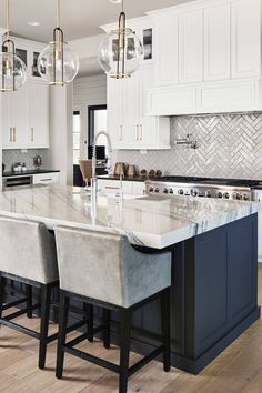 a large kitchen with white cabinets and marble counter tops, along with bar stools