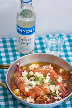 a pan filled with food next to a bottle of water