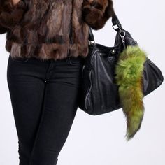 a woman wearing a fur coat and holding a handbag