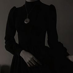 a woman wearing a black dress and necklace