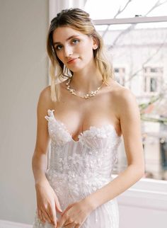 a woman in a wedding dress posing for the camera with her hand on her hip