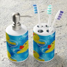 two toothbrush holders with rubber ducks on them, one is blue and the other is yellow