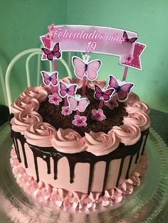 a birthday cake with pink frosting and butterflies on top