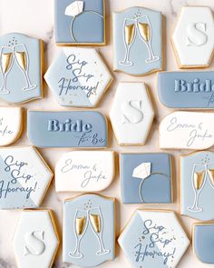 wedding cookies decorated with blue and white icing, champagne glasses and bride to be written on them