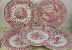 four red and white plates sitting next to each other on a wooden tablecloth covered floor