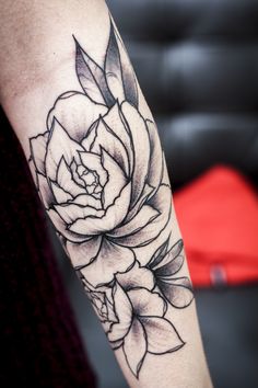 a black and white rose tattoo on the arm