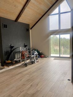 an empty room with wood floors and large windows