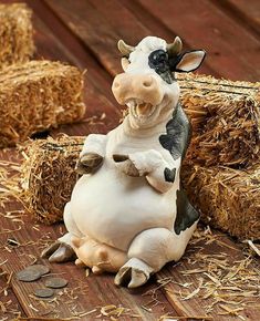 a cow figurine sitting on top of hay