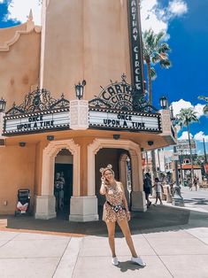 a woman standing in front of a movie theater