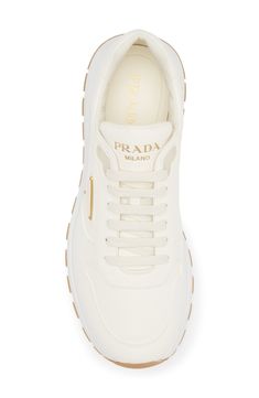 Prada takes a step to the future with a runner-style sneaker partially made from Re-Nylon, an industrial-inspired textile that can be endlessly regenerated. The iconic triangle logo first seen on trunks designed by Mario Prada in 1913 adds heritage style to your look. Lace-up style Removable insole Textile and leather upper/leather lining/rubber sole Made in Italy Designer Shoes Designer White Sneakers For Running, Sporty Sneakers With Logo Plaque For Streetwear, Sporty Streetwear Sneakers With Logo Plaque, Modern White Sneakers With Logo Plaque, Triangle Logo, Heritage Fashion, Up Styles, Designer Shoes, Prada